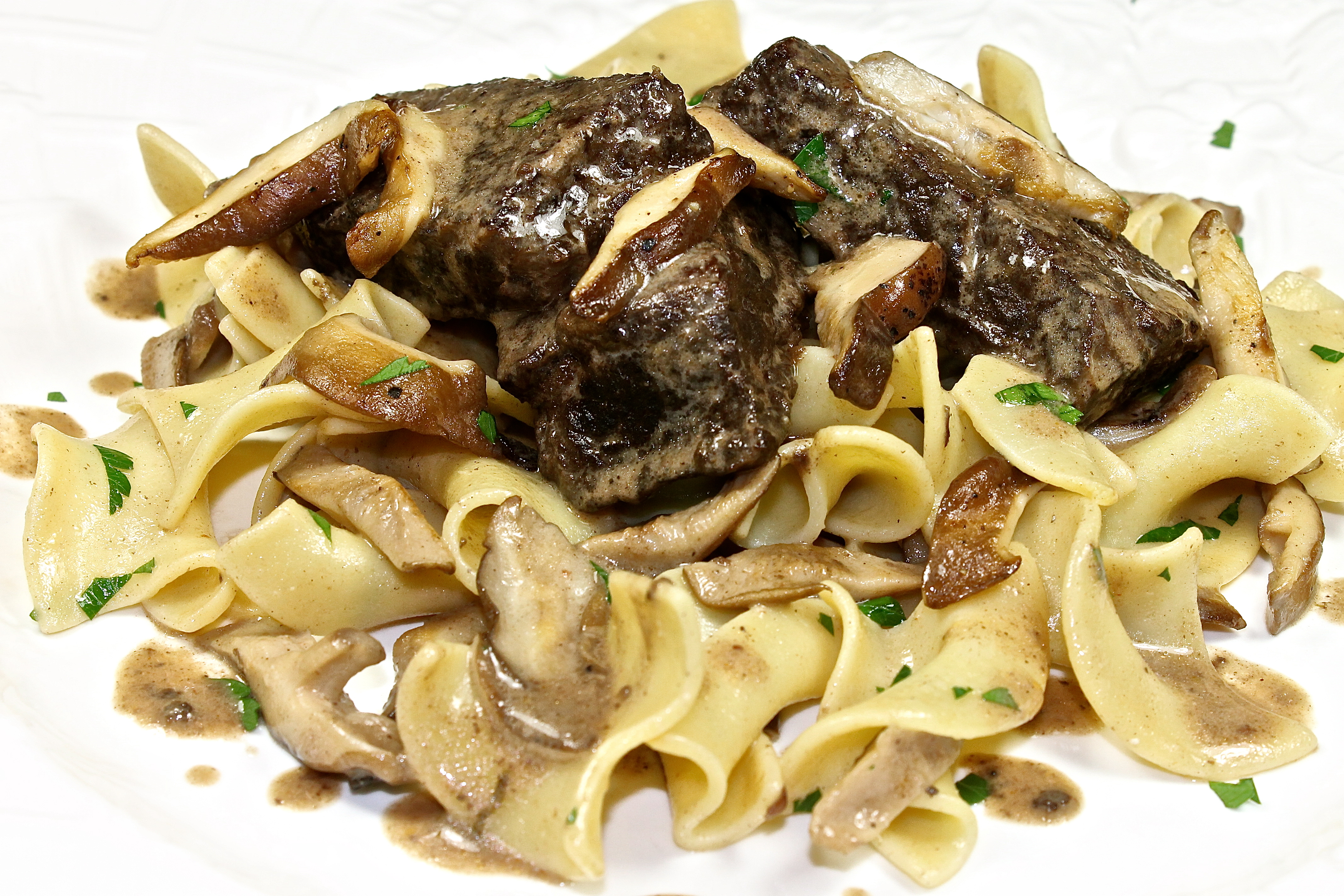 Braised Short Ribs With Wild Mushrooms Served Over Egg Noodles