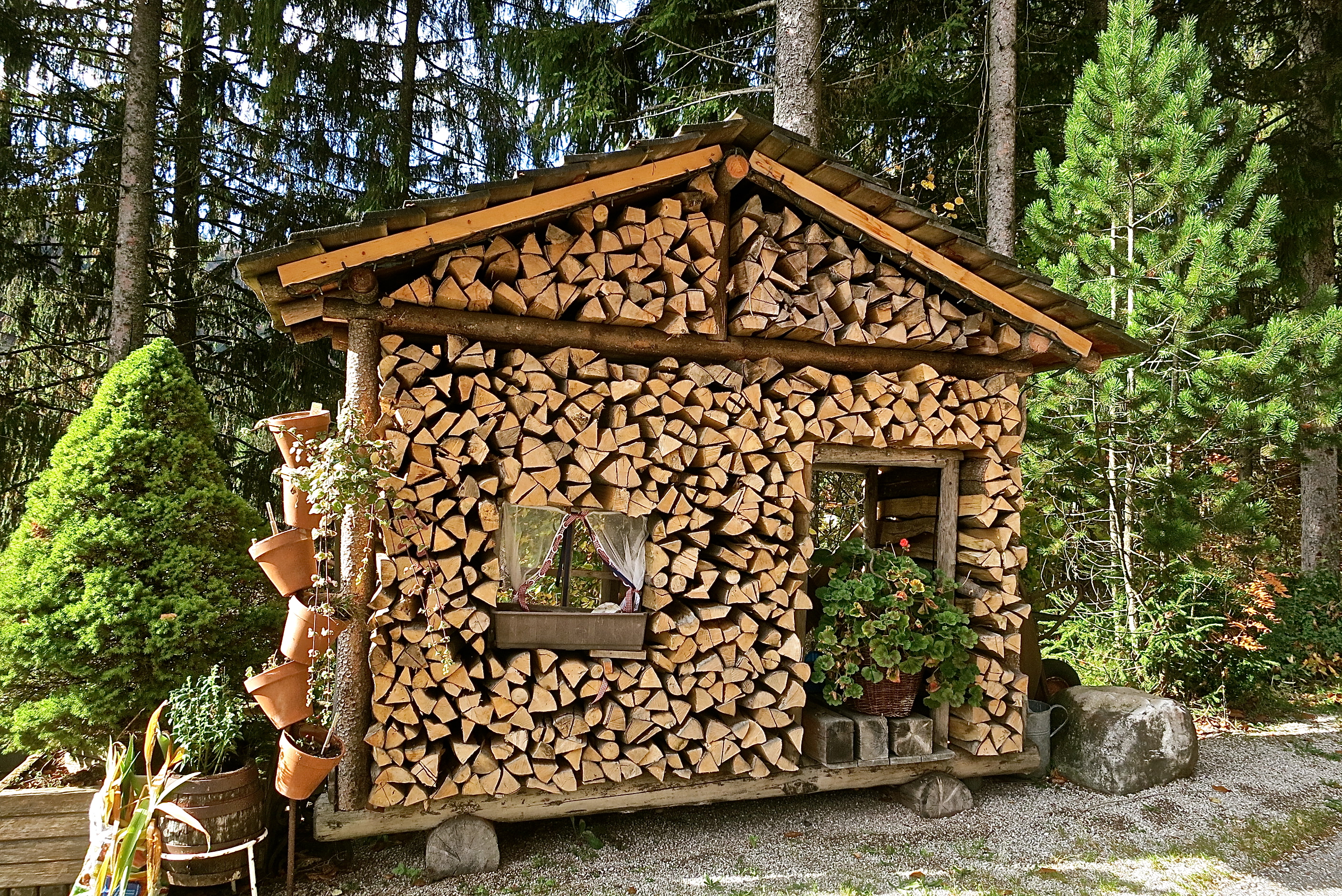 A Firewood Shed With Curtains In Its Windows