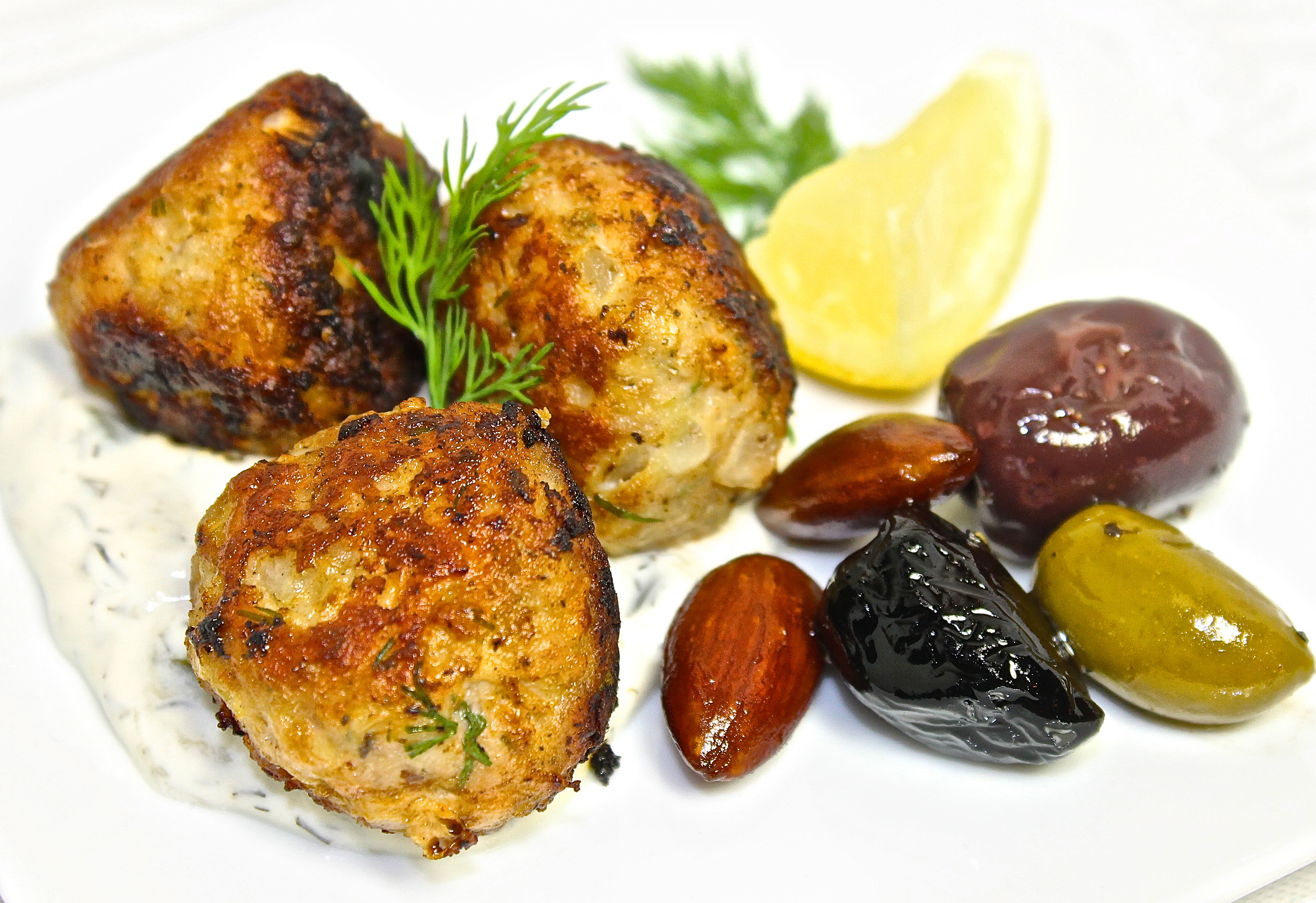 Small Plate Of Mediterranean Lamb Meatballs  On A Bed Of Takziki With Warm Almonds And Olives