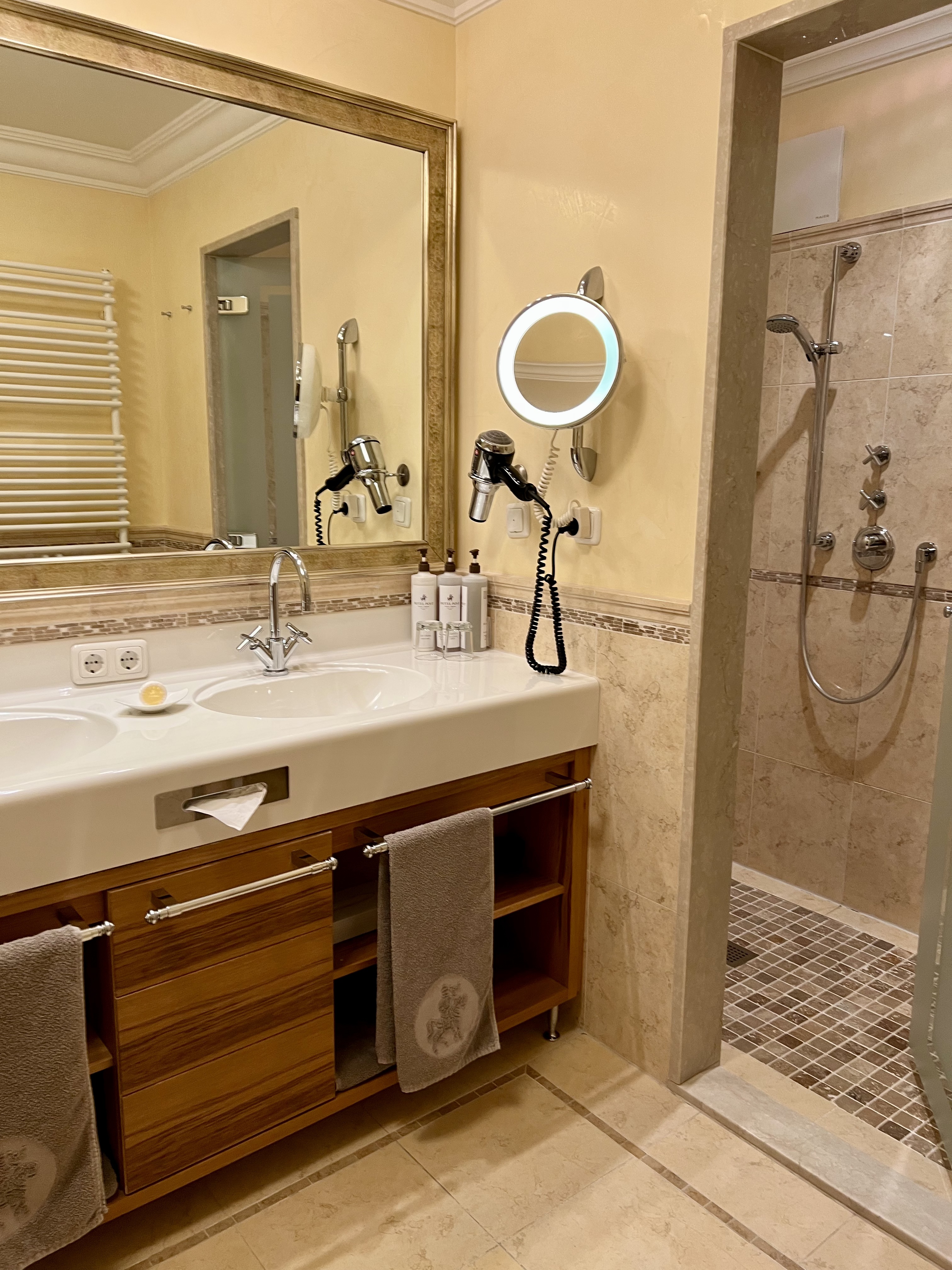 modern bathroom with double sinks, shower and bath