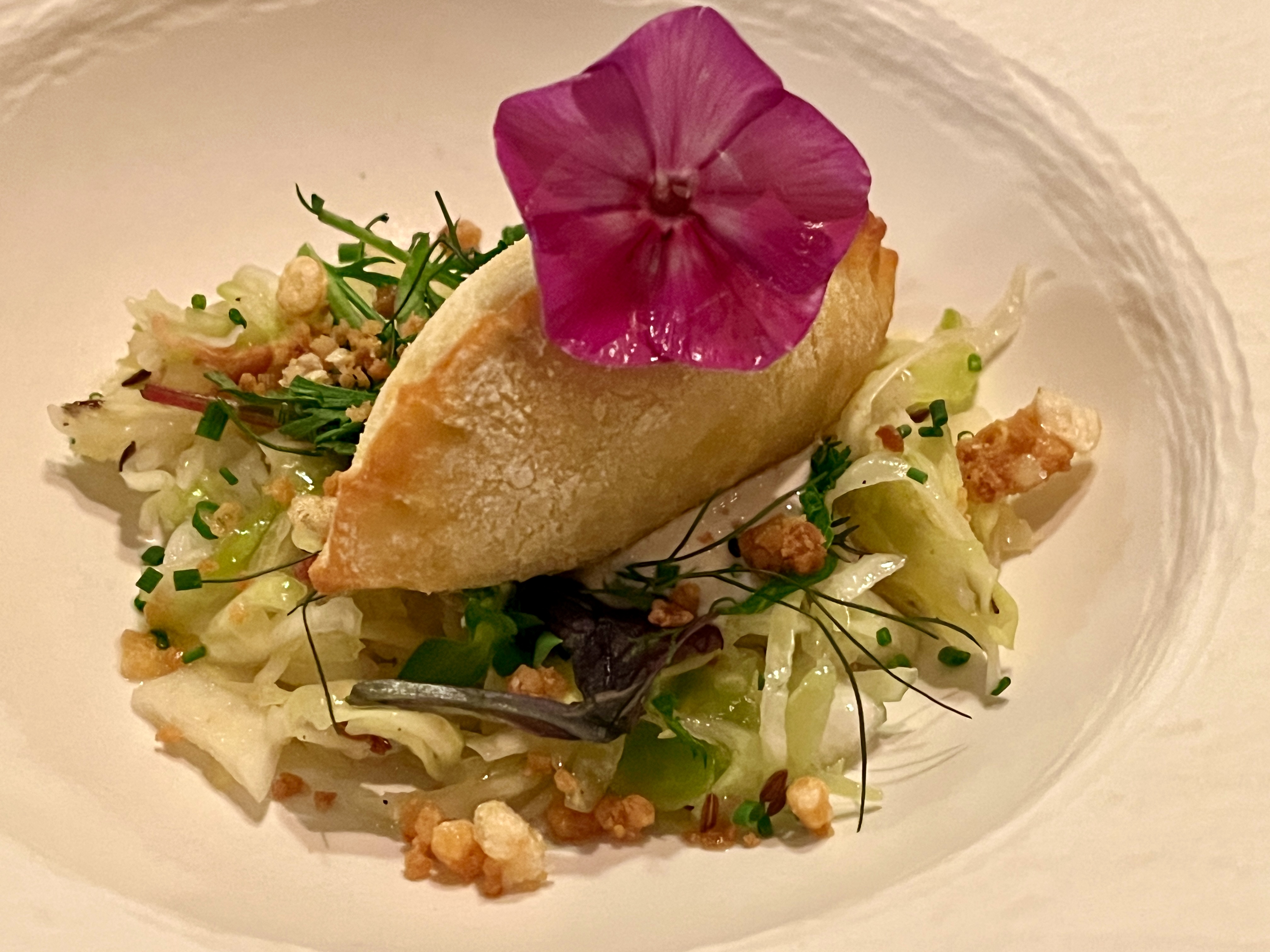 sausage pocket on warm cabbage with cumin cream and herbs