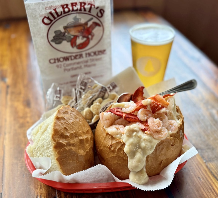 seafood chowder in a bread bowl and a glass of beer at Gilbert's chowder house in Portland Maine